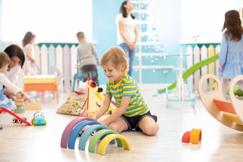 Children playing with colorful blocks. Kindergarten educational games.